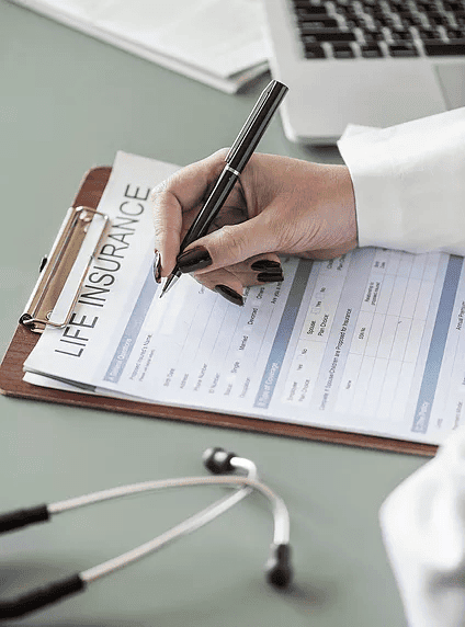 A doctor filing paperwork for life insurance plans