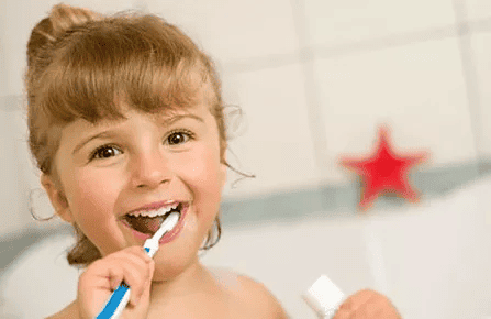A small child brushing their teeth